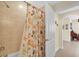Bathroom features tiled shower with colorful curtain and views to an adjacent room at 157 Tampa E Ave # 305, Venice, FL 34285