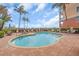 Community pool surrounded by lounge chairs and manicured landscaping at 157 Tampa E Ave # 305, Venice, FL 34285