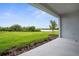 A view from the covered back porch onto a green lawn and calm body of water at 18136 Foxtail Loop, Venice, FL 34293