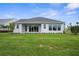 Well-manicured backyard featuring a white exterior and large windows at 18136 Foxtail Loop, Venice, FL 34293