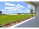 Scenic backyard view overlooking a serene lake, with lush green grass and a picturesque landscape at 18136 Foxtail Loop, Venice, FL 34293
