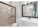 Modern bathroom with glass shower, marble tile, sleek white vanity, and matte black fixtures at 18136 Foxtail Loop, Venice, FL 34293