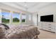 Relaxing bedroom boasts large windows with views of the greenery outside, wood-look floors and a dresser at 18136 Foxtail Loop, Venice, FL 34293
