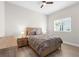 Bright bedroom featuring light wood floors, ceiling fan, and natural light from the large window at 18136 Foxtail Loop, Venice, FL 34293