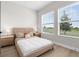 Bright bedroom with large windows and a lake view, wood-look floors, side tables and lamps at 18136 Foxtail Loop, Venice, FL 34293