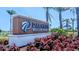 Palmera Wellen Park community entrance sign surrounded by red landscaping and palm trees under a sunny sky at 18136 Foxtail Loop, Venice, FL 34293