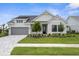 Charming two-story home featuring a gray garage door, stone accents, and well-manicured landscaping at 18136 Foxtail Loop, Venice, FL 34293