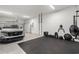 Well-lit garage with fitness equipment, work out area, and space for parking vehicles at 18136 Foxtail Loop, Venice, FL 34293