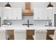 Modern kitchen with white cabinets, stainless steel appliances, and a stylish center island with bar seating at 18136 Foxtail Loop, Venice, FL 34293