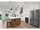 Bright kitchen featuring white cabinets, stainless steel appliances, a wine cooler, and an island with bar seating at 18136 Foxtail Loop, Venice, FL 34293