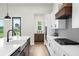 Well-lit kitchen featuring a large island with a sink and modern appliances, complemented by a view to the outside at 18136 Foxtail Loop, Venice, FL 34293
