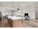 Open-concept kitchen with island seating, modern appliances, and a view to the living and dining areas at 18136 Foxtail Loop, Venice, FL 34293