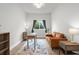 Bright living room with cozy seating, a rustic desk, and a view of backyard at 18136 Foxtail Loop, Venice, FL 34293