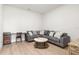 Cozy living room featuring a comfortable sofa, a desk, and a stylish round coffee table on wood-look flooring at 18136 Foxtail Loop, Venice, FL 34293