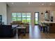 Open-concept living room featuring a view of the lake, a kitchen island with pendant lights, and light wood floors at 18136 Foxtail Loop, Venice, FL 34293
