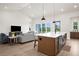 Open-concept floorplan featuring a living area with couches flowing into the kitchen area at 18136 Foxtail Loop, Venice, FL 34293