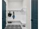 Mud room with patterned tile floor, built-in storage bench, hooks, and stylish teal doors at 18136 Foxtail Loop, Venice, FL 34293