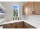 Convenient pantry with ample counter space, cabinets, and shelving for organized storage at 18136 Foxtail Loop, Venice, FL 34293