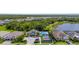 A high aerial of the community pool, tennis courts, and houses with a beautiful treeline backdrop at 19927 Bridgetown Loop, Venice, FL 34293