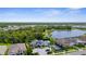 A high aerial view of the community with the pool and tennis courts surrounded by trees and houses at 19927 Bridgetown Loop, Venice, FL 34293