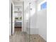 Bathroom showcasing glass shower with pebble floor, tile walls, and doorway to bedroom at 19927 Bridgetown Loop, Venice, FL 34293
