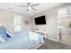 Comfortable bedroom featuring a ceiling fan, mounted TV, and stylish decor at 19927 Bridgetown Loop, Venice, FL 34293