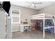 Bright bedroom features a ceiling fan, large window, a desk, and a white bunk bed with toys at 19927 Bridgetown Loop, Venice, FL 34293