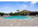 A clear in ground community pool and deck furniture surrounded by black aluminum fencing at 19927 Bridgetown Loop, Venice, FL 34293