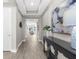 Beautiful hallway with tray ceiling, wood-look floors, console table and modern art at 19927 Bridgetown Loop, Venice, FL 34293