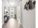 Inviting foyer with wood-look floors, tray ceiling, and elegant chandelier at 19927 Bridgetown Loop, Venice, FL 34293