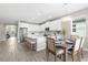 Well-lit kitchen and dining area with stainless steel appliances, white cabinets and plenty of seating space at 19927 Bridgetown Loop, Venice, FL 34293