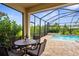 Covered patio with comfortable seating overlooks a private pool and landscaped backyard, perfect for outdoor living at 19927 Bridgetown Loop, Venice, FL 34293