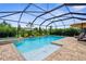 Screened-in pool with a spa, sun deck, and tropical landscaping at 19927 Bridgetown Loop, Venice, FL 34293