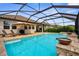 Inviting outdoor pool features a spacious patio area with lounge chairs and a well-manicured backyard at 19927 Bridgetown Loop, Venice, FL 34293