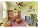 Cozy bedroom with ceiling fan, leather chair, and bookshelf at 20169 Cristoforo Pl, Venice, FL 34293