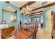 Open dining room with wooden beams, a chandelier, and view of the living room at 20169 Cristoforo Pl, Venice, FL 34293