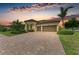 Home exterior with lush landscaping and a brick driveway at 20169 Cristoforo Pl, Venice, FL 34293