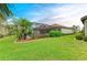 Well-manicured lawn and tropical landscaping surround the screened-in pool in this home's backyard at 20169 Cristoforo Pl, Venice, FL 34293