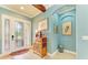 Inviting foyer featuring tile floors, blue walls, and a decorative cabinet with stylish accents at 20169 Cristoforo Pl, Venice, FL 34293