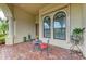 Inviting front porch area with a seating arrangement and arched windows at 20169 Cristoforo Pl, Venice, FL 34293