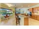 Bright kitchen with wood cabinets, granite counters, breakfast bar, and view of the pool at 20169 Cristoforo Pl, Venice, FL 34293