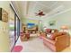 Living room with coffered ceiling, leather furniture, and sliding glass doors to the patio at 20169 Cristoforo Pl, Venice, FL 34293