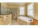 This spa-like bathroom includes a luxurious soaking tub, a walk-in shower with glass doors, and stylish fixtures at 20169 Cristoforo Pl, Venice, FL 34293