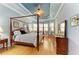 Spacious main bedroom featuring a four-poster bed, tray ceiling, and ample natural light at 20169 Cristoforo Pl, Venice, FL 34293