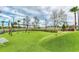 A playground with a swingset, and slide built into a grassy hill, perfect for outdoor activities at 20169 Cristoforo Pl, Venice, FL 34293