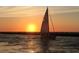 A captivating sailboat sailing towards a sunset horizon, creating a picturesque nautical scene at 20169 Cristoforo Pl, Venice, FL 34293