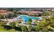 Aerial view of a community pool with abundant seating, palm trees and well-maintained landscaping at 20443 Cristoforo Pl, Venice, FL 34293