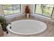 Relaxing bathroom featuring a large soaking tub and natural light from the window at 20443 Cristoforo Pl, Venice, FL 34293