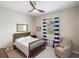 Cozy bedroom with a ceiling fan and a comfortable sitting area by the window at 20443 Cristoforo Pl, Venice, FL 34293