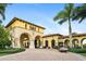 Community clubhouse features an inviting entrance, classic architecture, and a convenient golf cart at 20443 Cristoforo Pl, Venice, FL 34293